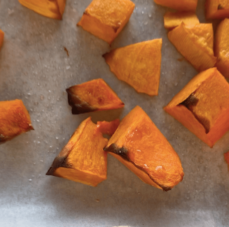 A tray of roasted cubed pumpkin with charred and caramelised edges
