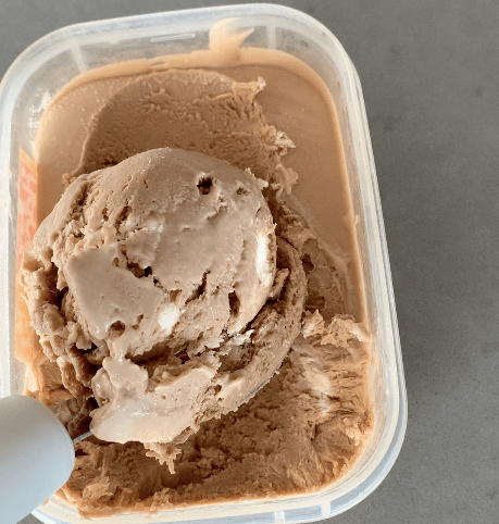 A scoop of Milo Ice cream resting in it’s tub