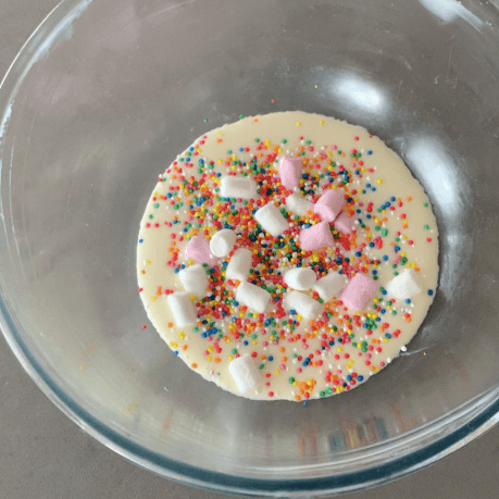 A bowl of ice cream mix with marshmallows and sprinkles