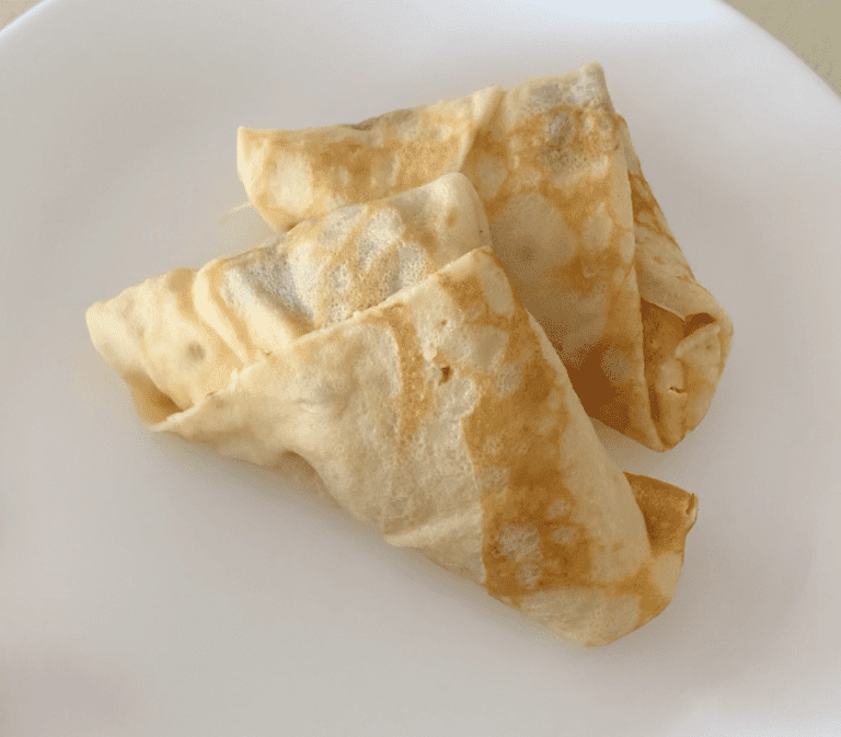 A white plate with 2 small, triangular crepe parcels
