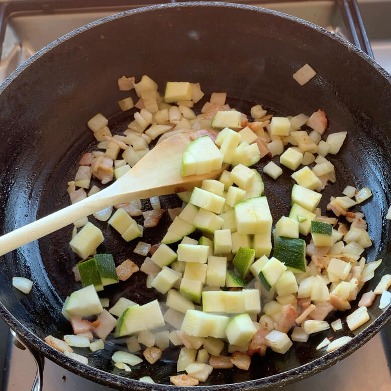 diced Zucchini, onion and bacon in a frypan