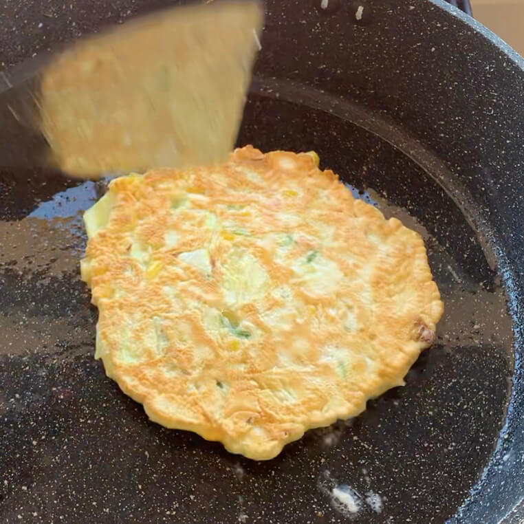 Okonomiyaki being cooked in a pan