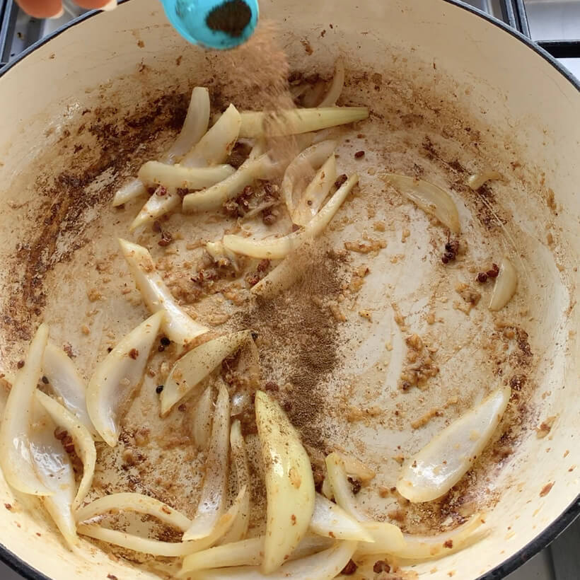 Onions and sichuan peppercorns in a white pan