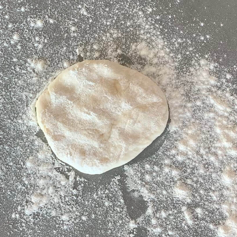 Small round of dough on a floured bench