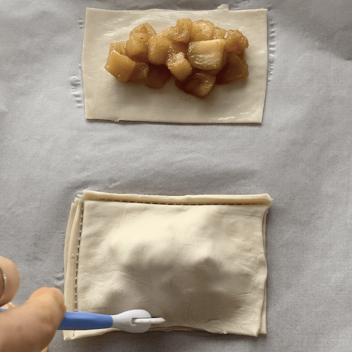 Trimming edges of pastry from apple pie pockets