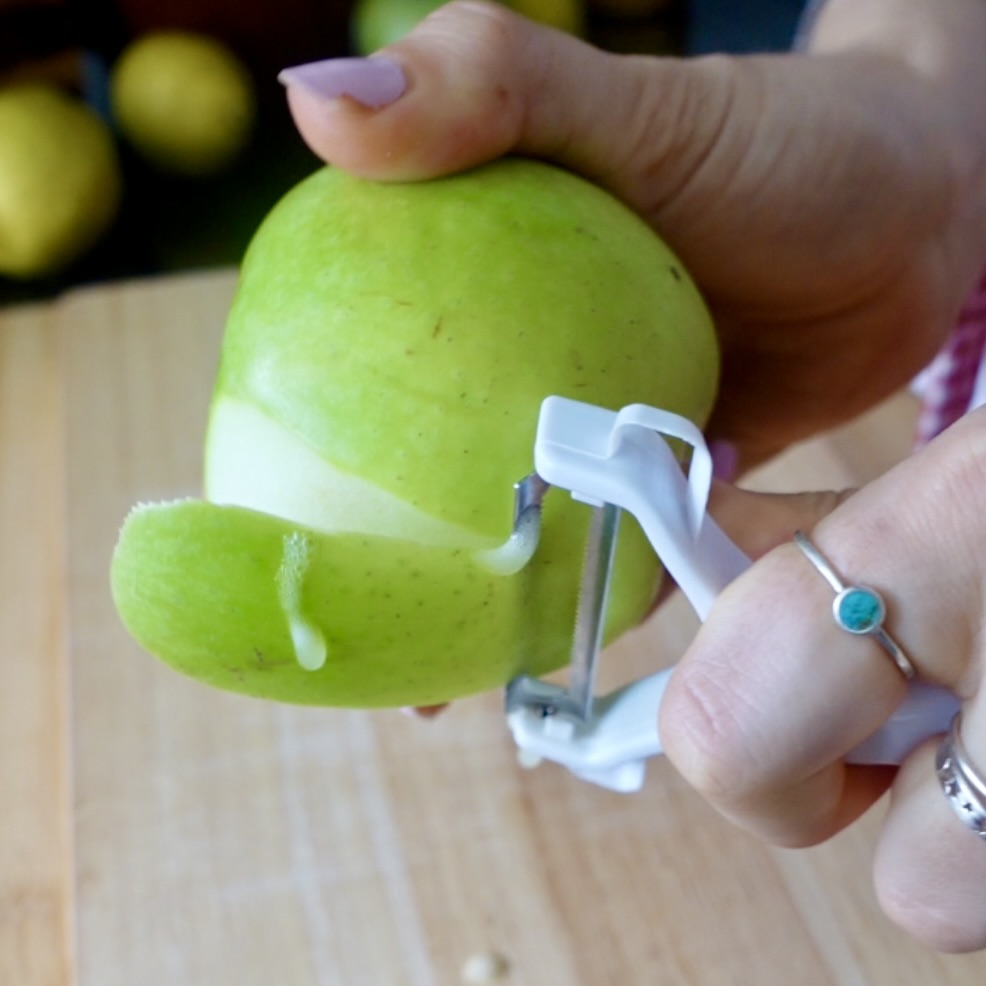 Peeling the skin off a granny smith apple
