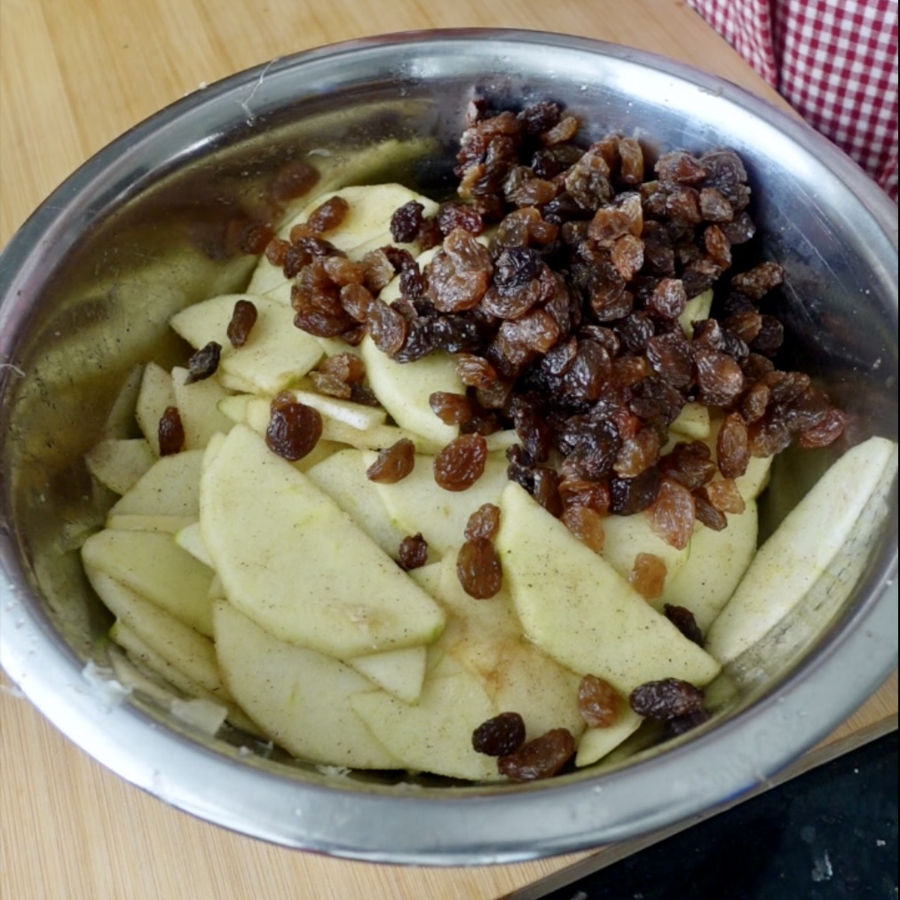 Sliced apples and raisins in a metal bowl